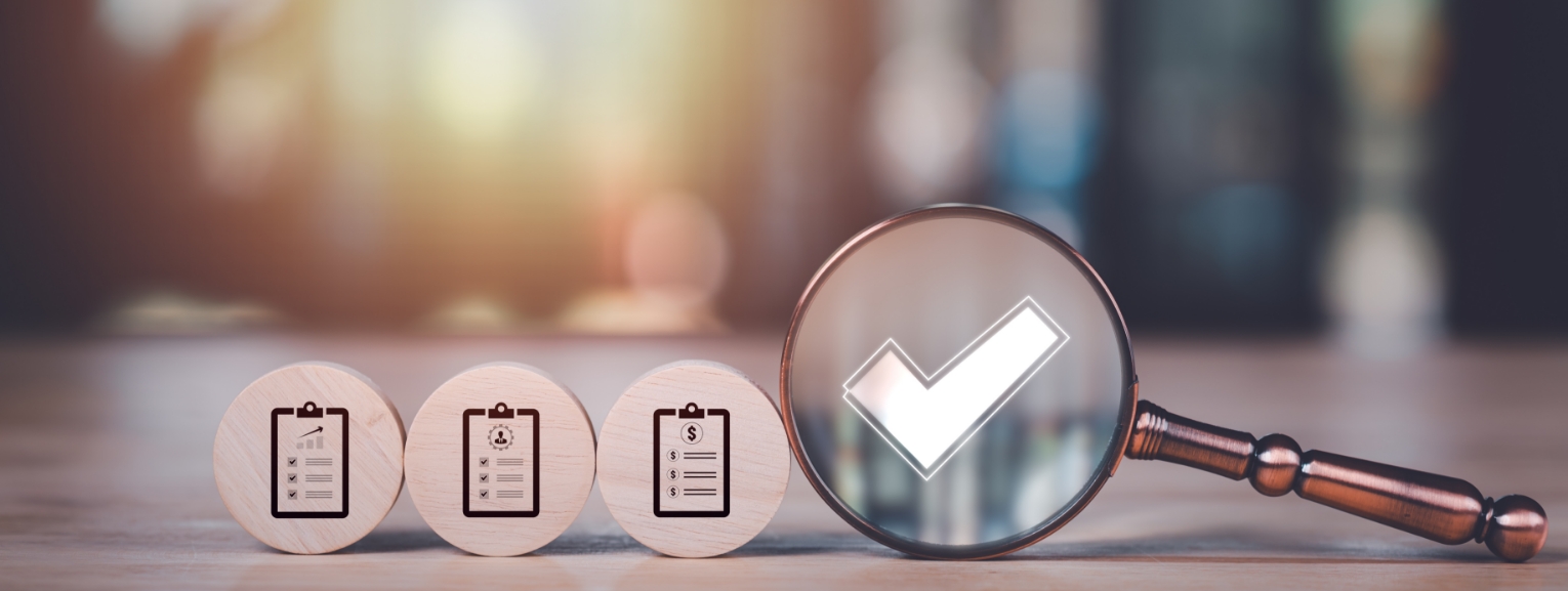 Magnifying glass focusing on checkmark representing remote audit efficiency in the pharmaceutical industry.